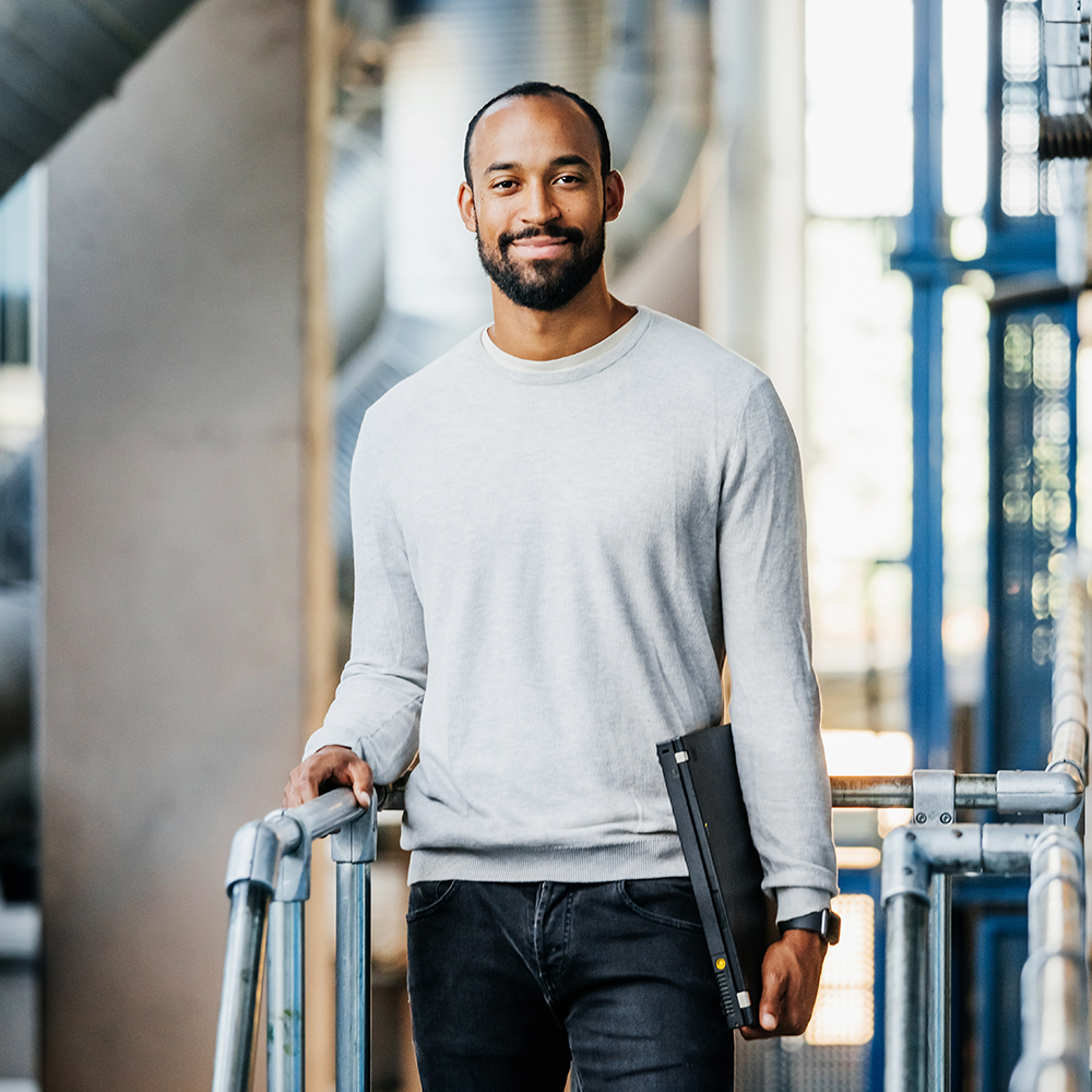 Image of a man in an industrial setting with a labotop