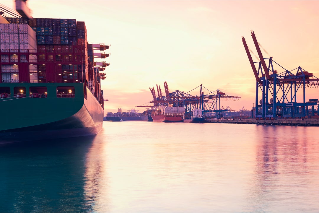 container ships with harbor and sunset in the background