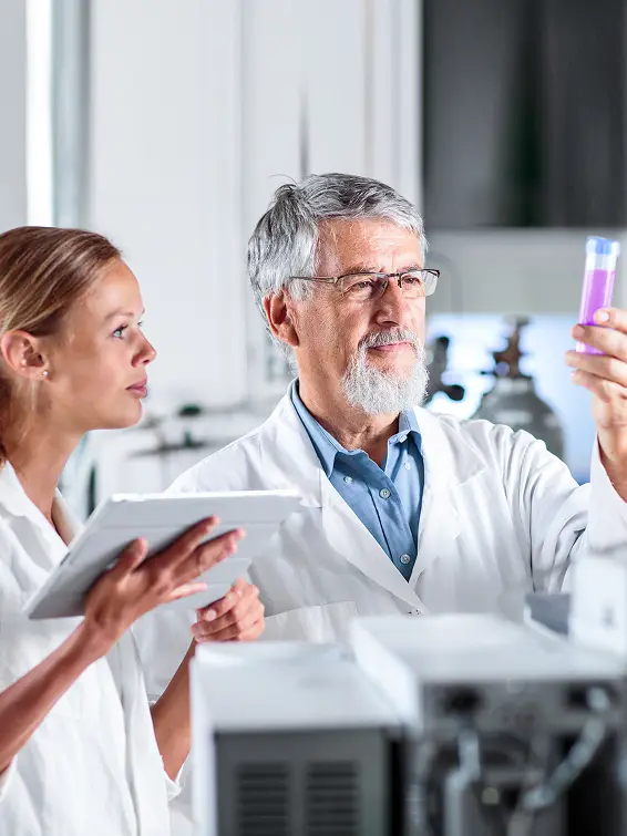 two laboratory assistants look at a test tube