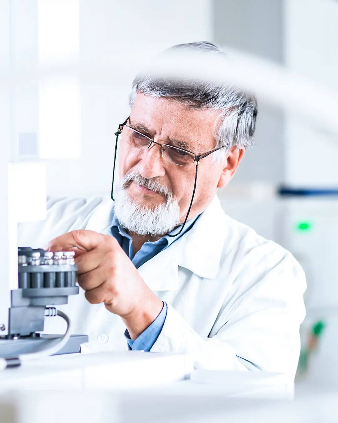 Man in a lab coat at a microscope
