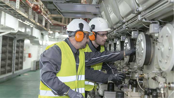 two service employees inspecting an engine